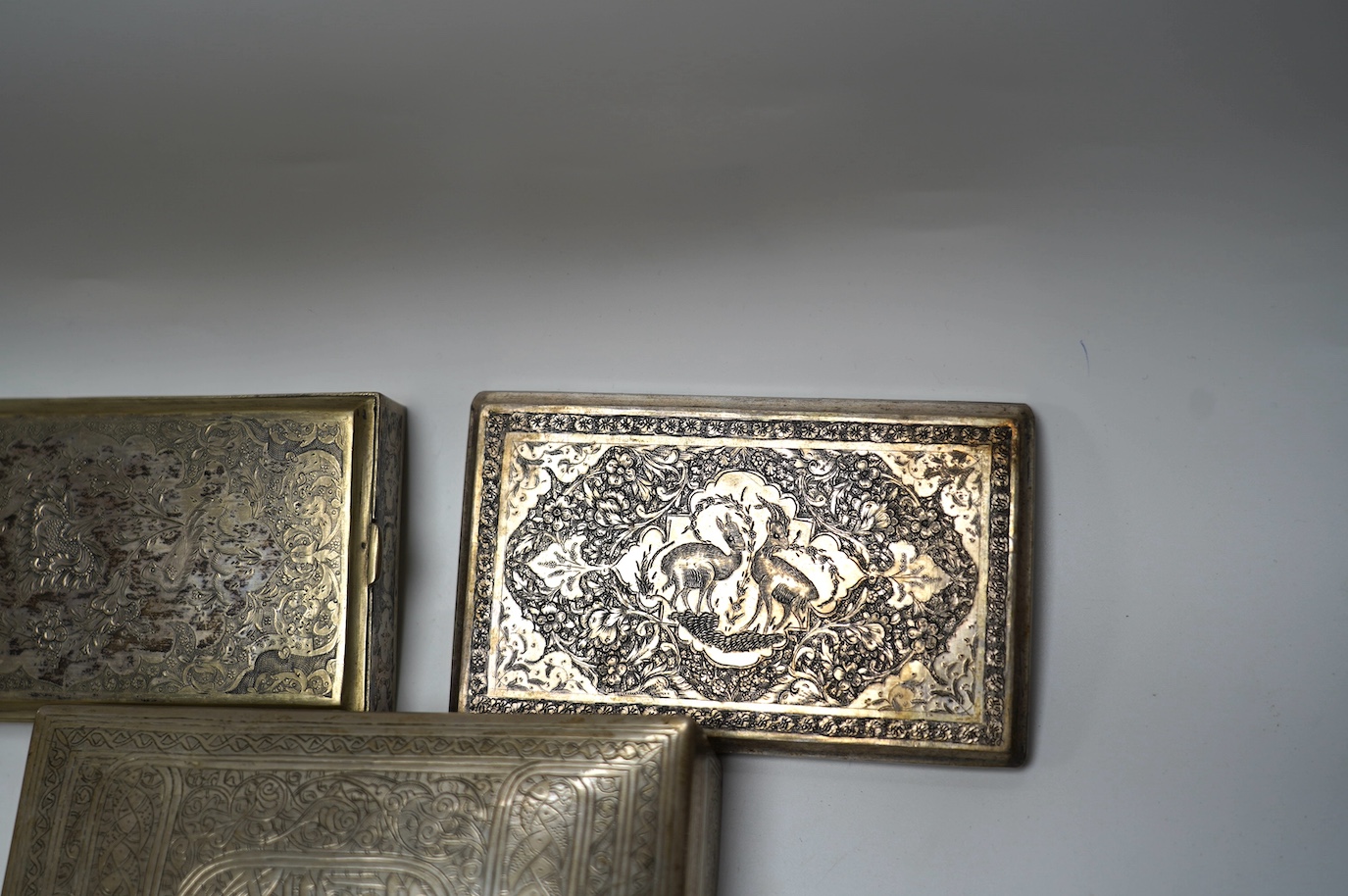 An Egyptian white metal cigarette box, 14,5cm, a Persian white metal cigarette box and similar cigarette case, gross weight 26.6oz. Condition - poor to fair